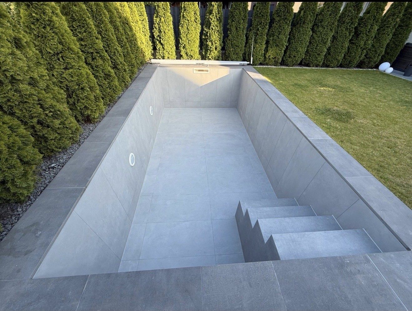 Neu gebauter Pool mit grauer Fliesung